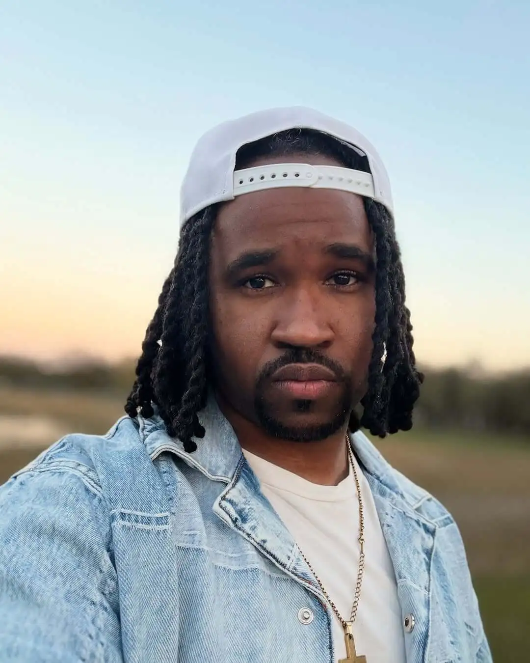 A selfie of Prospering with a hat and jeans jacket on