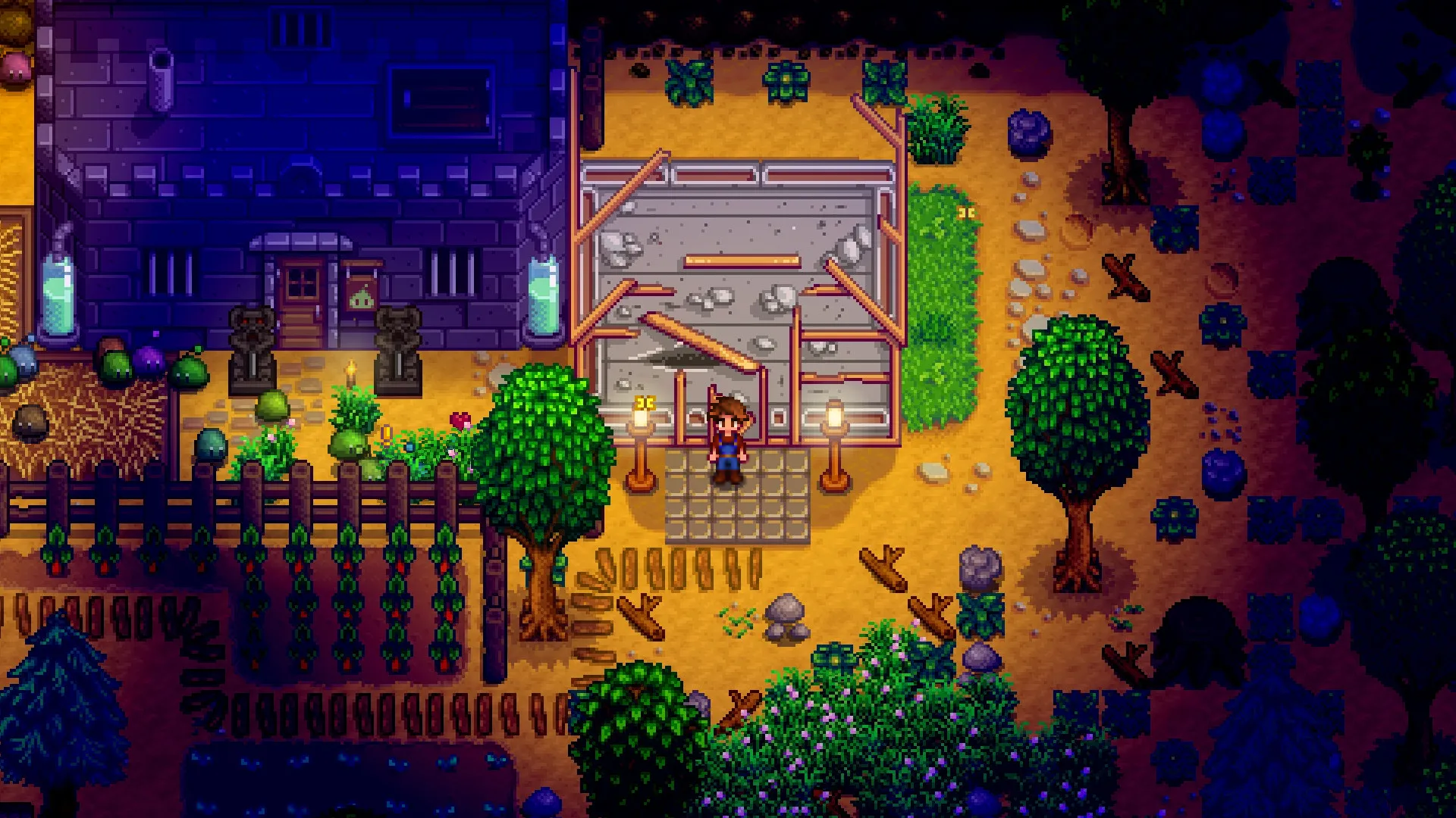 A player character standing outside buildings at night in Stardew Valley.