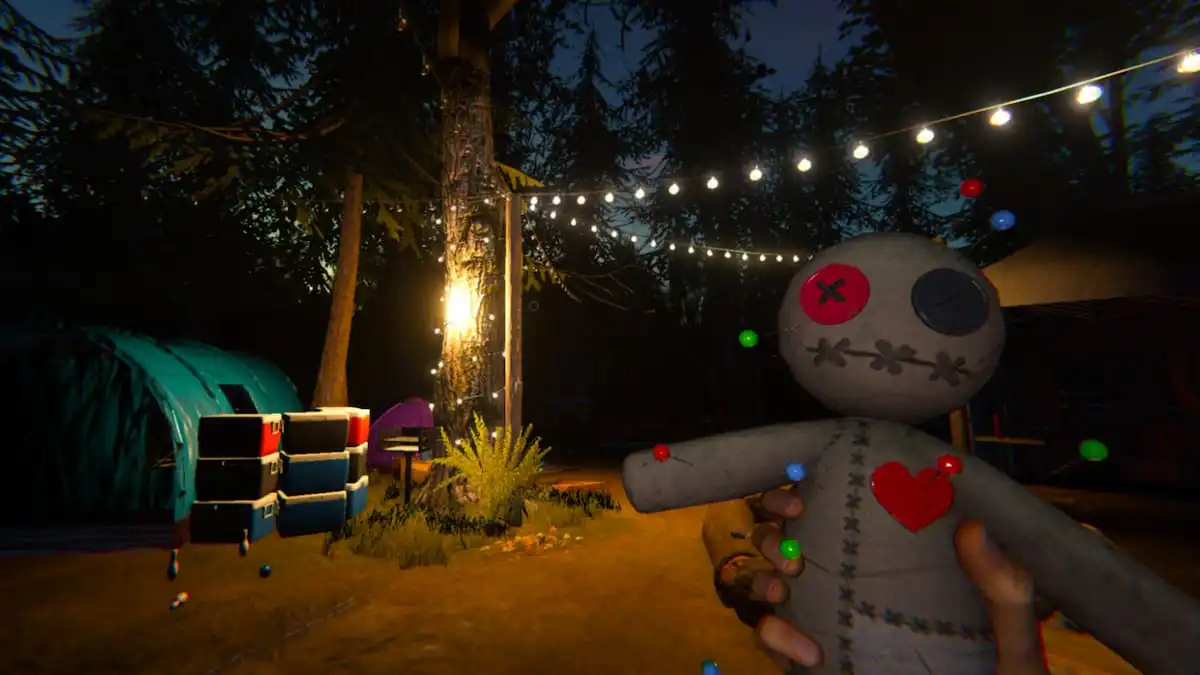 The player holding a voodoo doll in their hand and staring at a lit up camp while searching for a ghost in Phasmophobia.