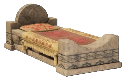 A bed with a stone headboard and foot board with red blankets on it