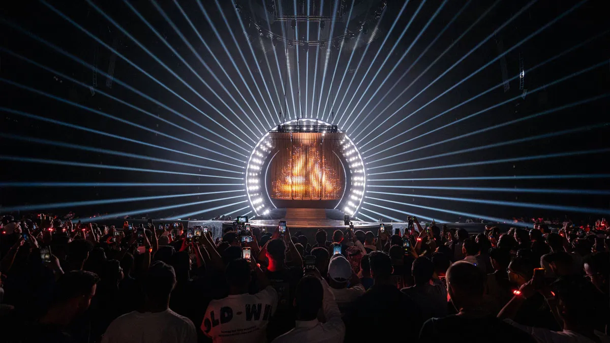 The closing ceremony of the Esports World Cup with a large crowd watching a lighting show on-stage.