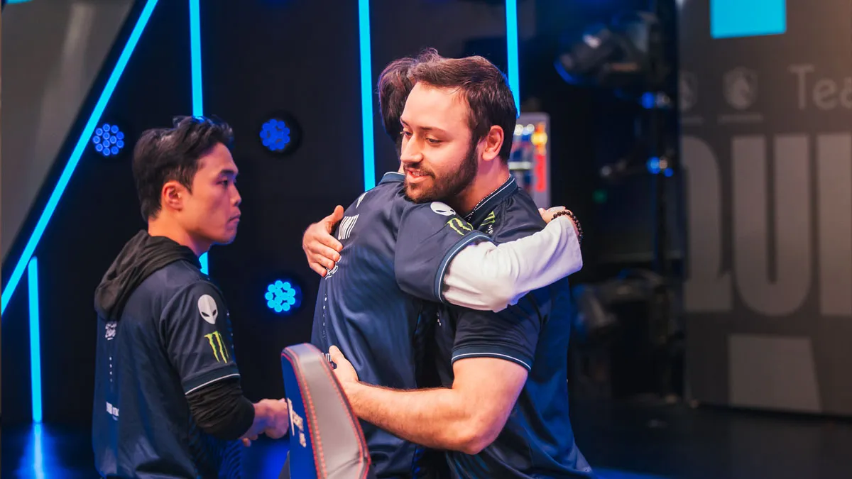 UmTi and APA embrace after completing an undefeated LCS season on-stage.