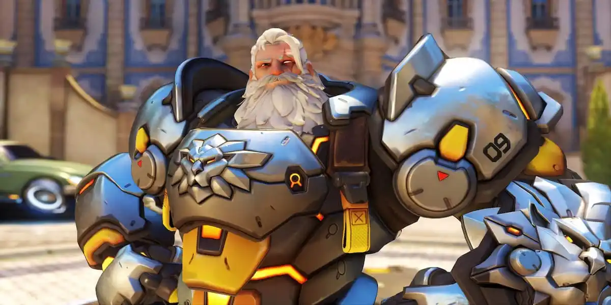 Reinhardt in a suit of silver armor with a lion on the chest smiles in OW2