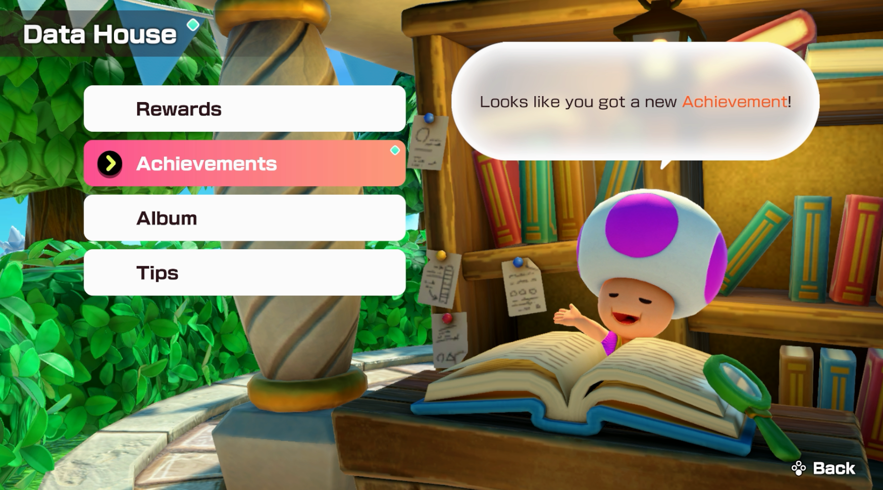 a toad in mario party sits behind a book as he offers the player a list of options to choose from