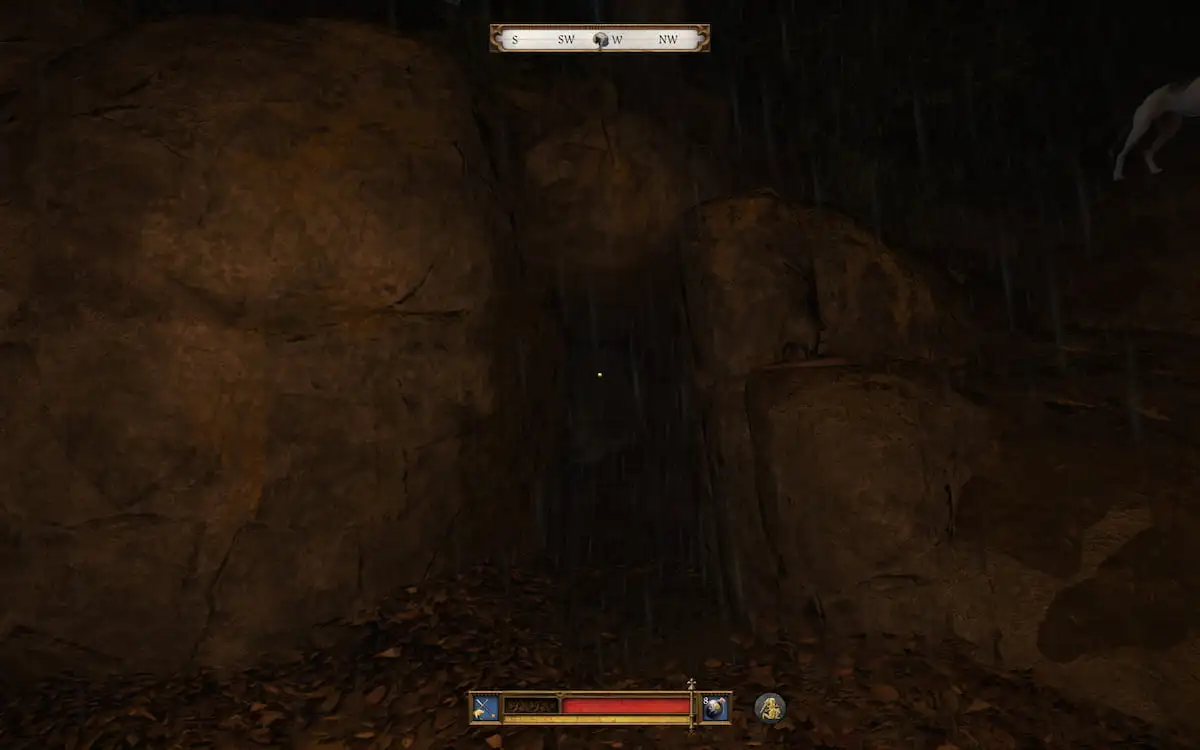 Player character standing in front of a cave entrance with rocks around while it rains in the background