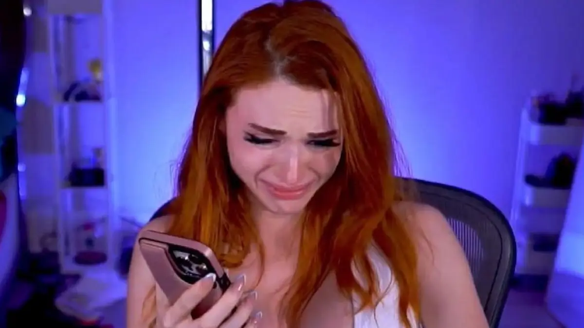 Amouranth holding her phone and crying